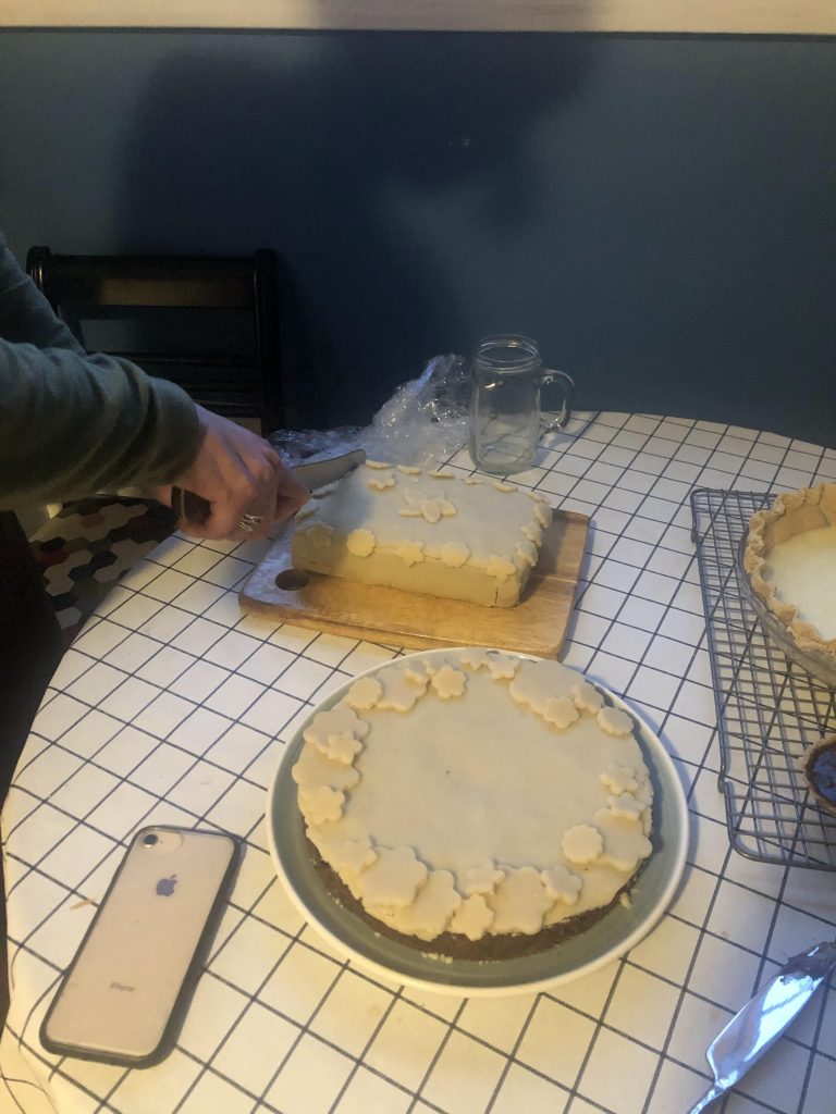 Two fruit cakes, one is being sliced.