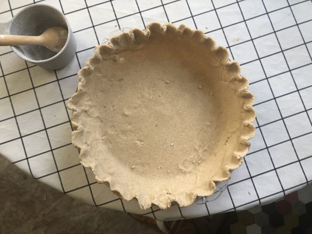 a pie plate with a raw pie crust inside it.