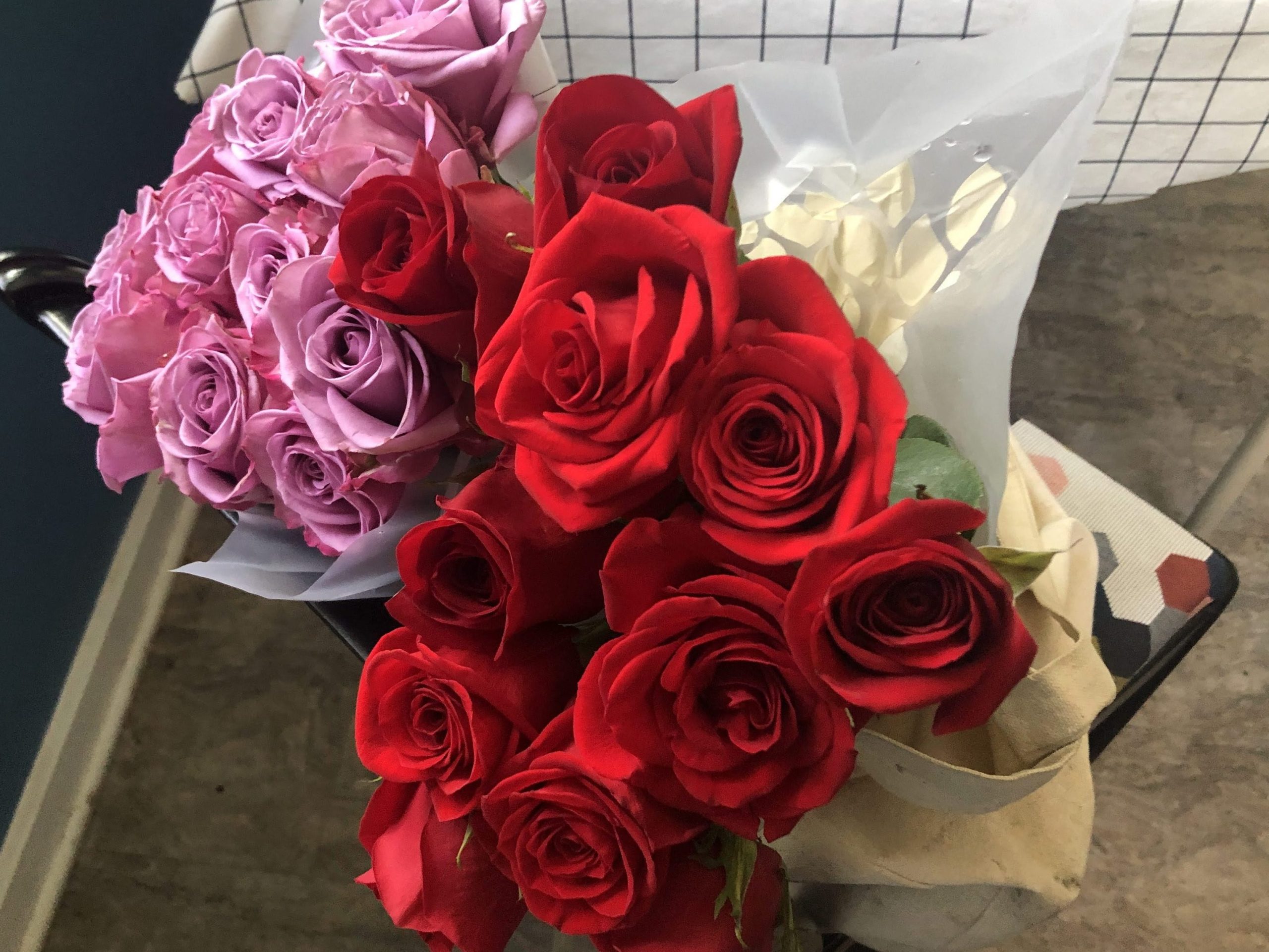 A bouquet of pink roses and a bouquet of red roses.