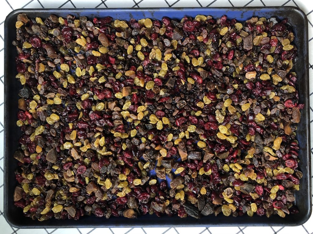 blue tray covered in a mix of dried fruit: dark raisins, golden raisins, cranberries, apricots, currants.