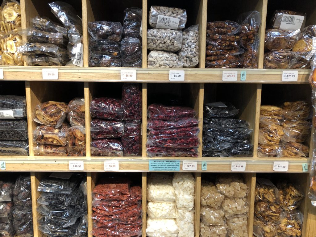 Shelves and cubbies full of packaged dried fruit, packaging is clear with small or non-visible labels.