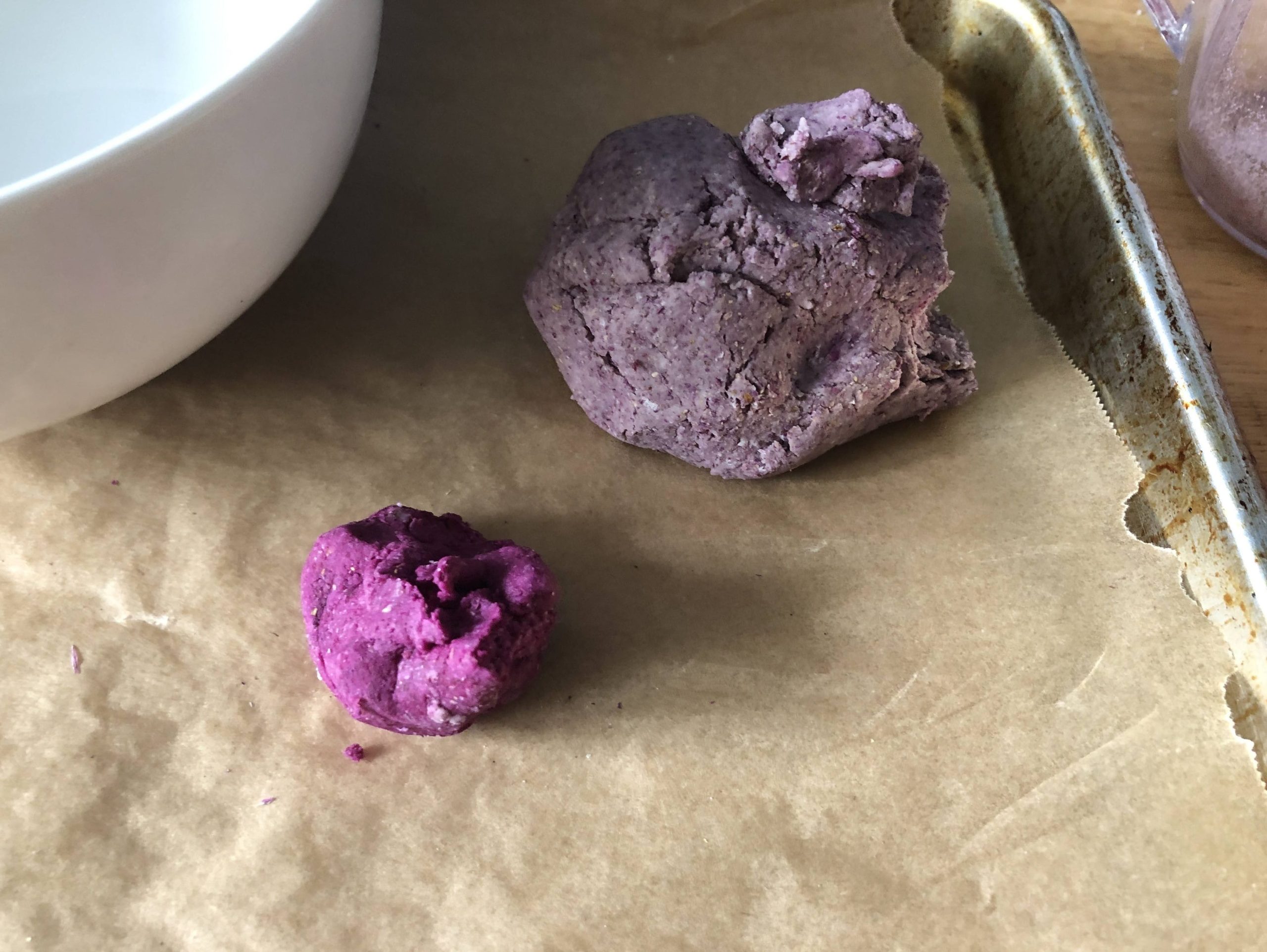 a small hunk of bright purple clay and a larger hunk of a muted gray/purple clay.