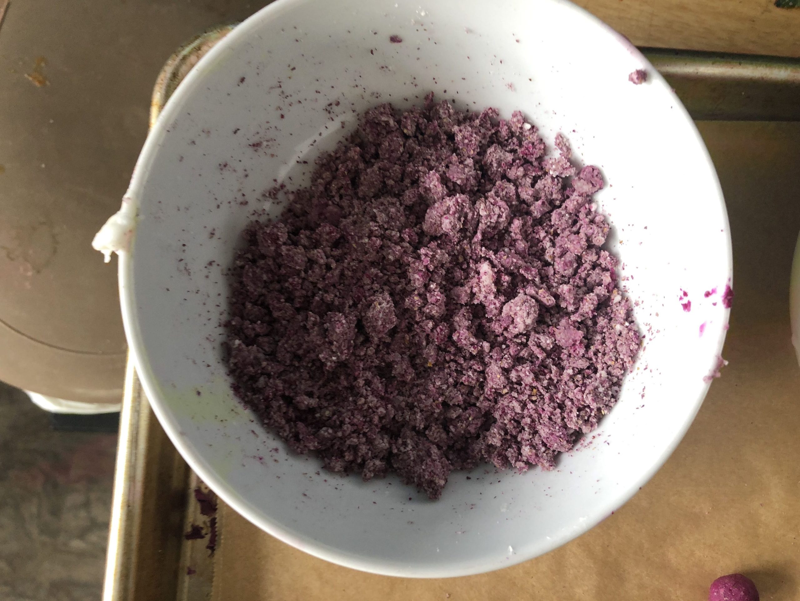 A white bowl full of clumps of something like wet purple sand
