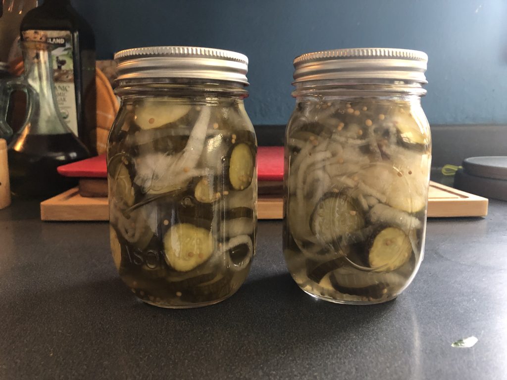 two jars of sliced pickles and onion.